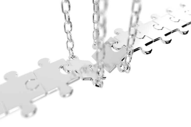 白色背景上带银链子的拼图
