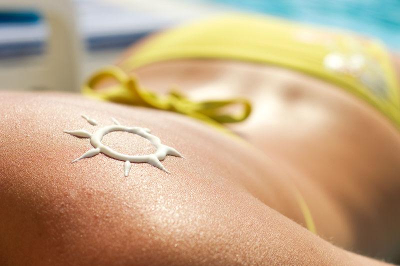 女子沙滩上肩膀上涂上防晒霜的太阳