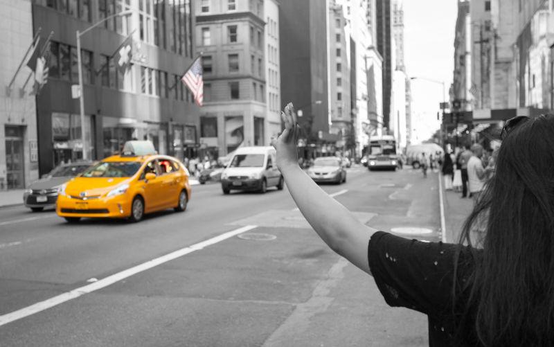 游客在曼哈顿打一辆黄色出租车