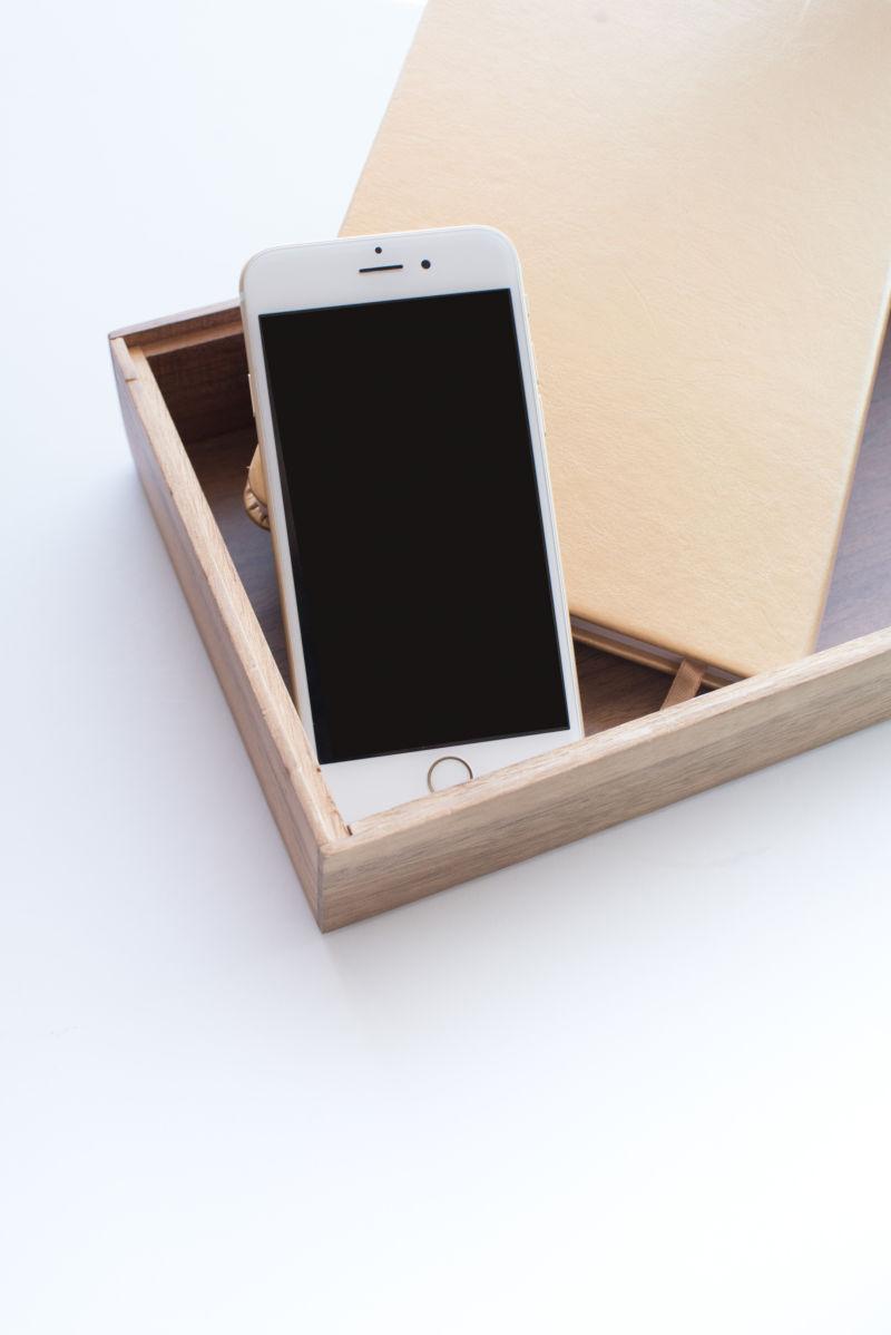 桌面盒子里的手机和笔记本