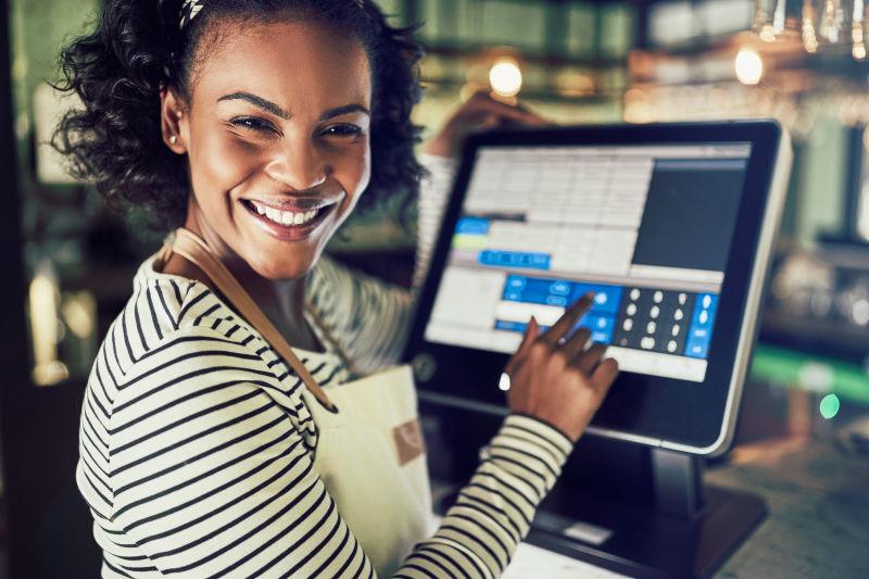 微笑的年轻女服务员使用餐厅销售点终端