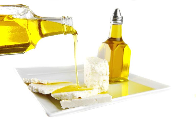 白色背景上的倒上橄榄油的白色豆腐