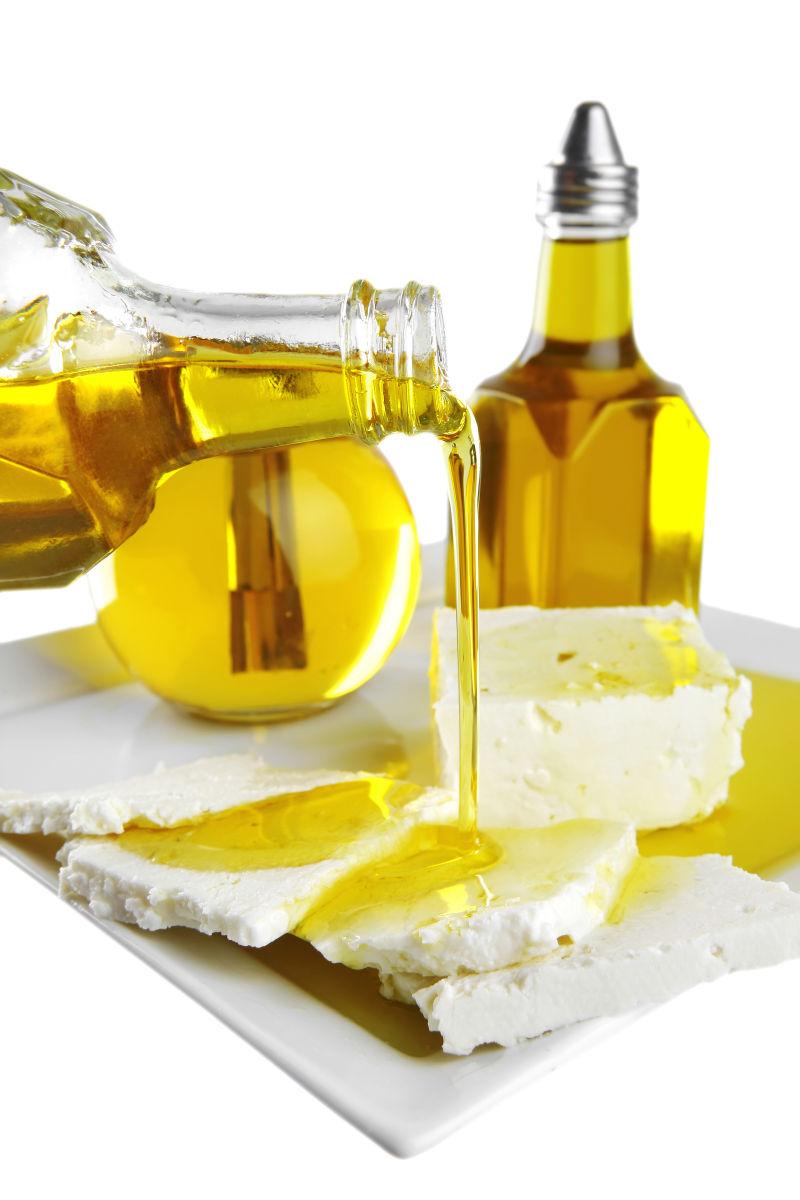 白色背景上的向白色馒头片上倒入橄榄油