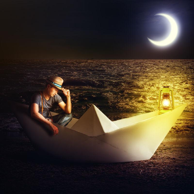 夜色下坐在纸船上的男人