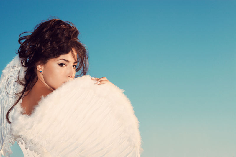 蓝色背景中的白色翅膀的美女