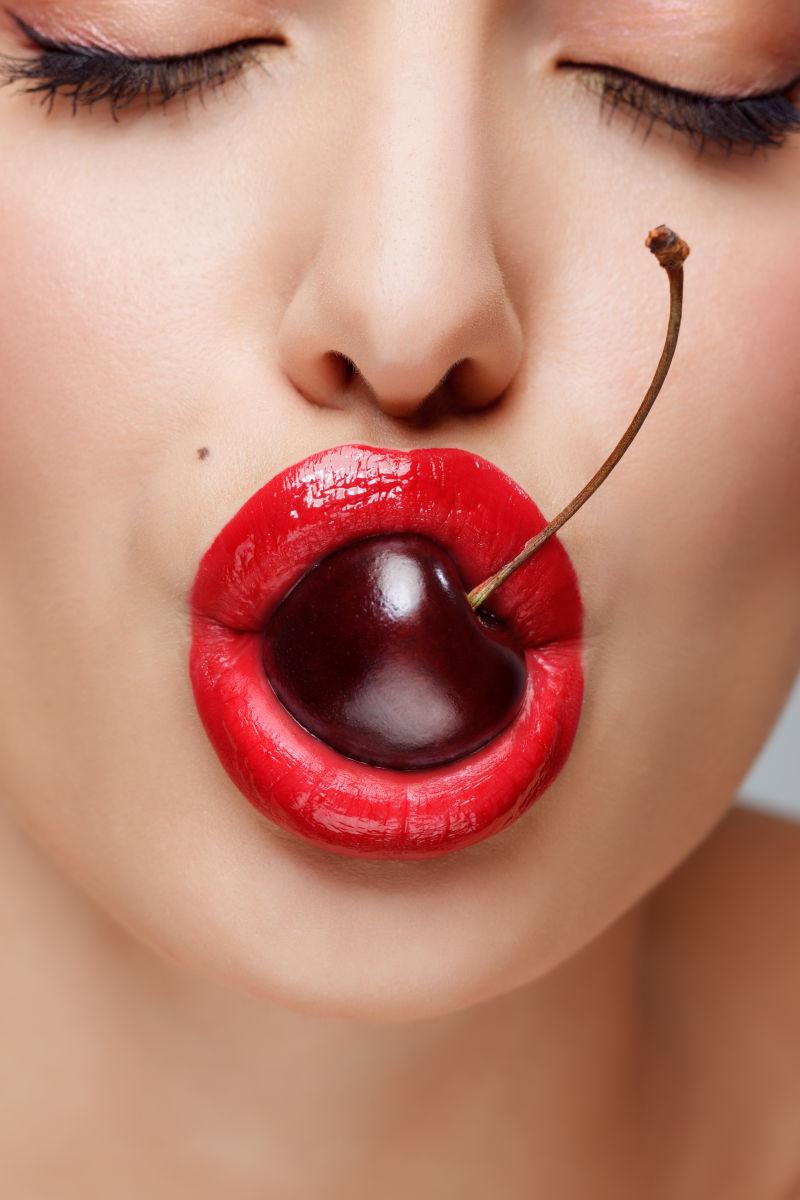 图片 创意图片 漂亮女人的嘴巴叼着美味樱桃嘴唇是在