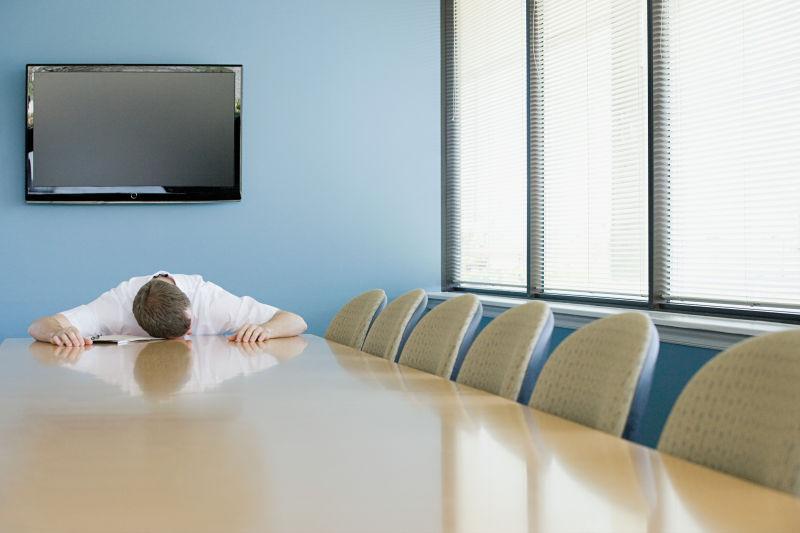 趴在会议桌上睡觉的男人