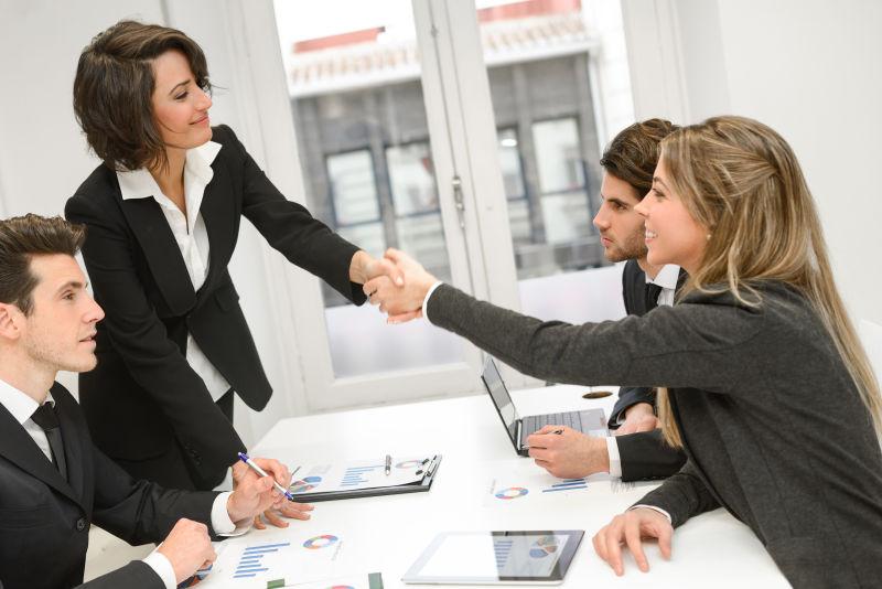 会议中握手的双方团队