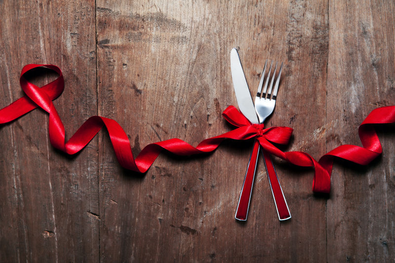 木桌上系了红丝带的刀叉
