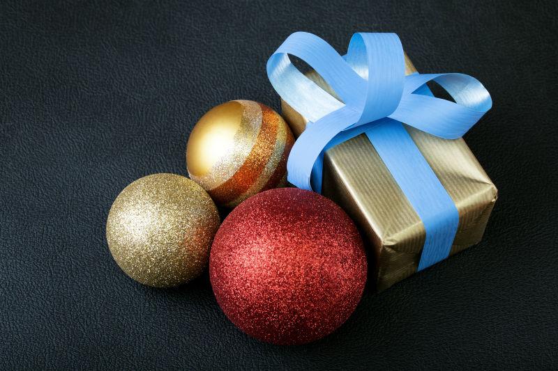 黑色背景下的圣诞球和礼物盒