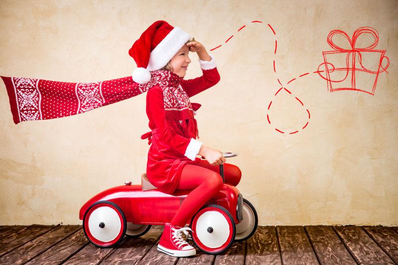 屋子里坐在玩具汽车上的小孩