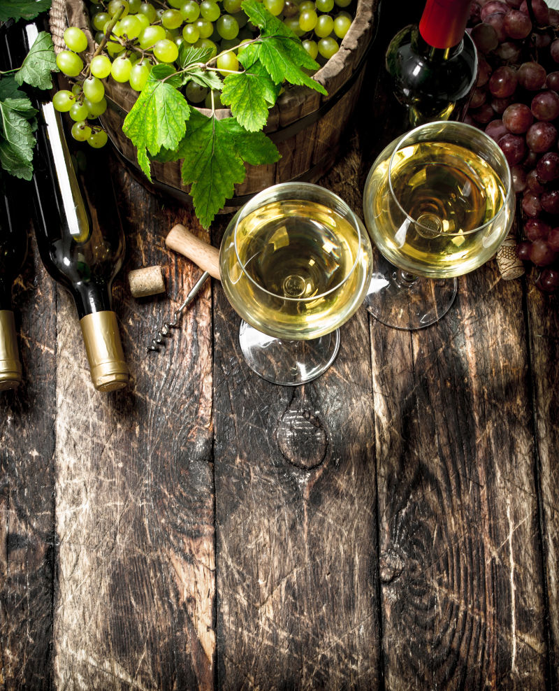 木桌上的白葡萄酒与葡萄