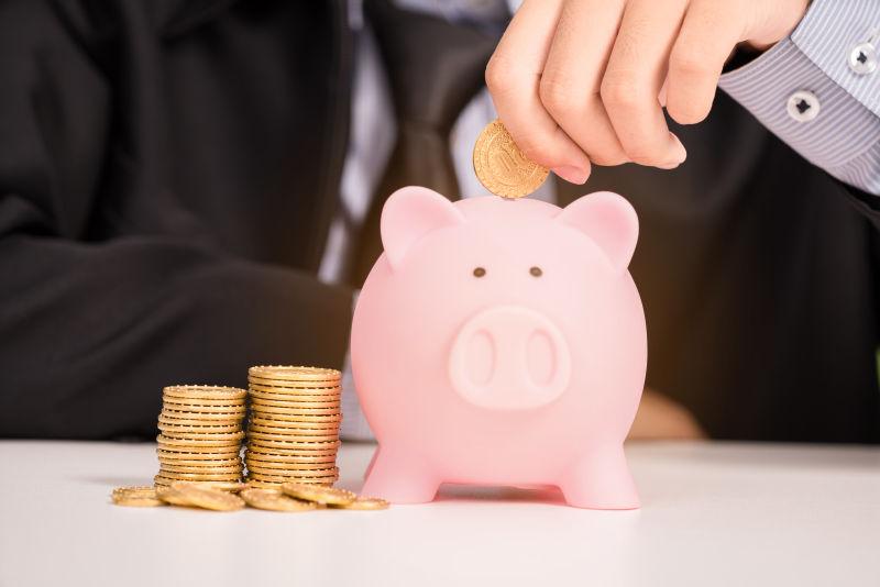 商人把金币塞进储蓄罐