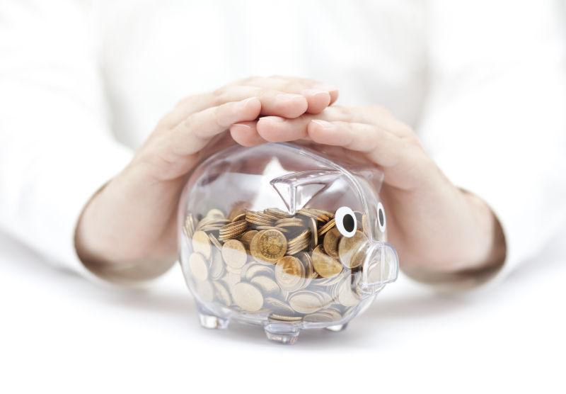 用手覆盖硬币的透明储币罐