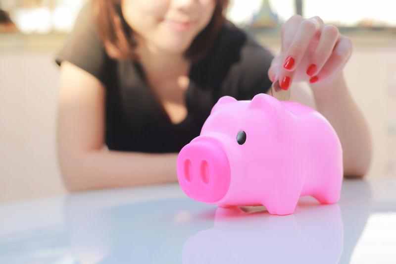 女人把钱放进存钱罐里