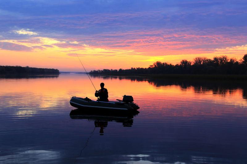 清晨一艘充气船上的秋千渔夫