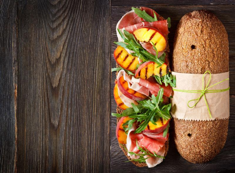 木制背景上的美味的火腿三明治