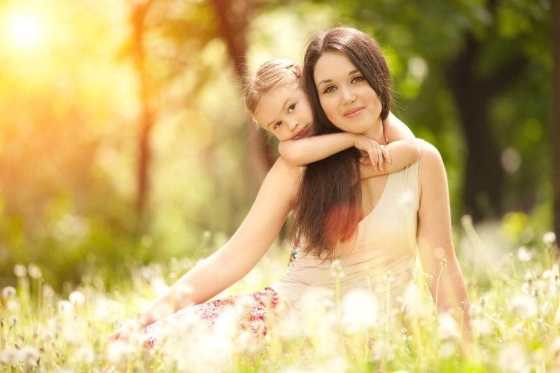 阳光下公园里开心的妈妈和女儿