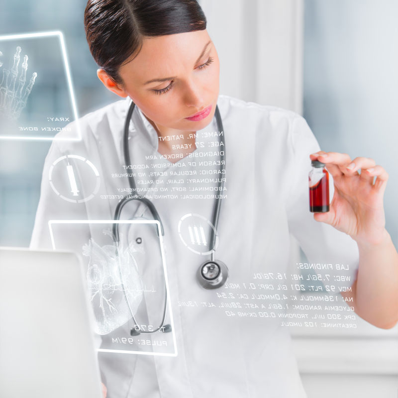 漂亮的女性实验室助手用虚拟显示器分析笔记本电脑附近的血样