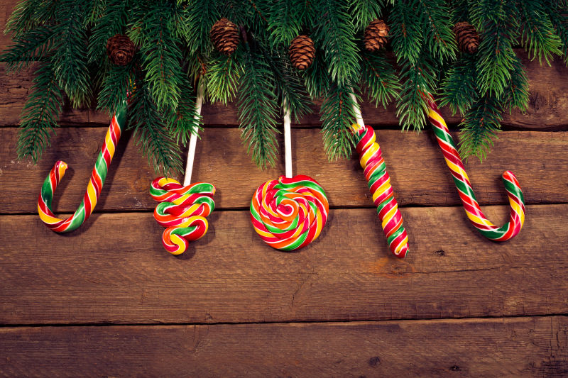 木制背景中的圣诞树上装满糖果