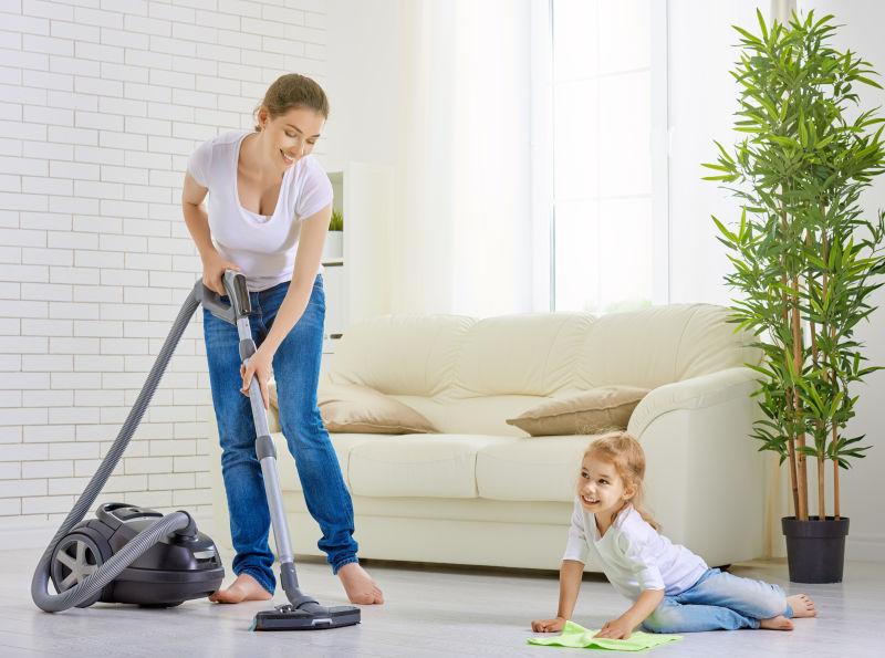 客厅里的打扫卫生的母亲和地上的小女孩