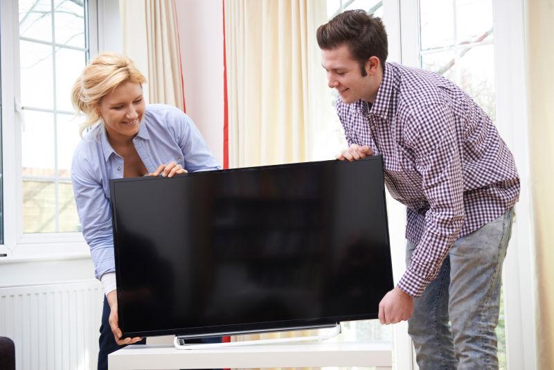 卧室里抬着电视的夫妻