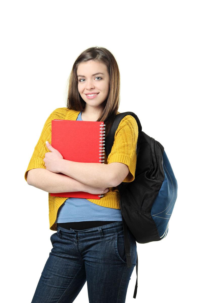 带着书包的拿着书的女大学生