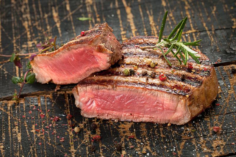 木制背景下新鲜美味的牛排烤肉