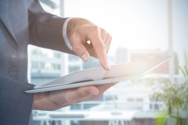 伸手触摸平板电脑屏幕的商人