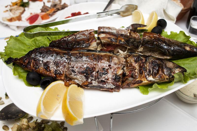 盘子里的烤鱼配柠檬片