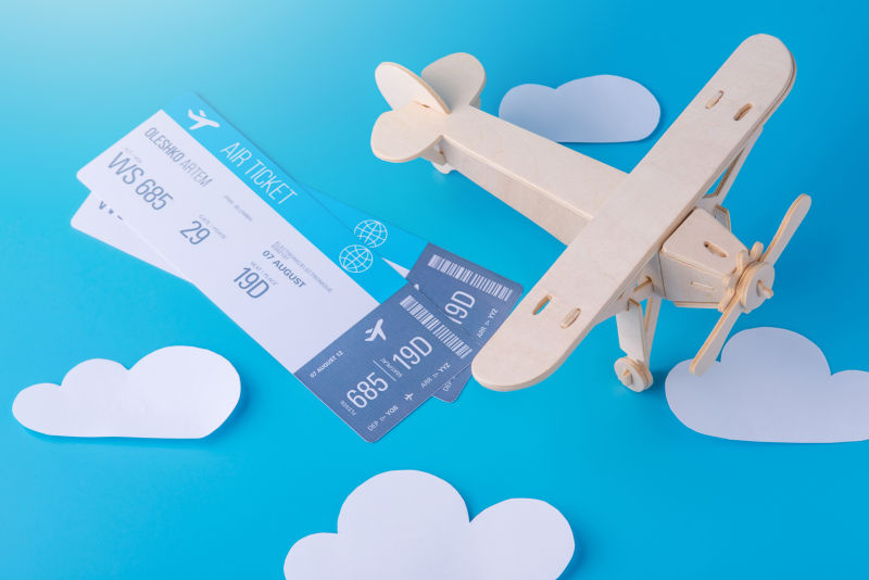 蓝色背景上的飞机票和木飞机