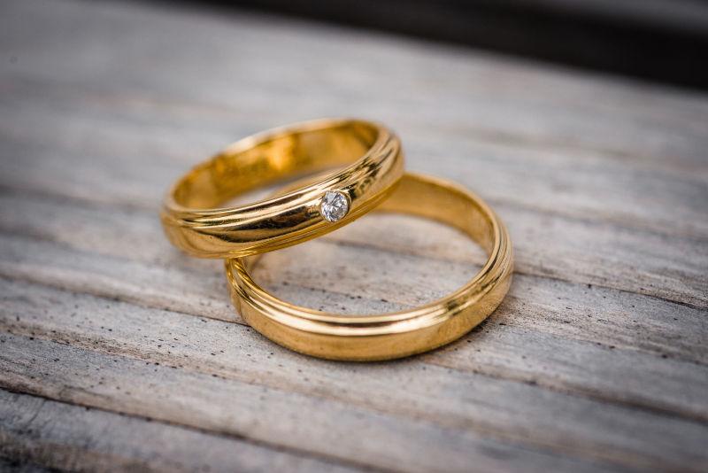 木桌上的一对镶钻的金色戒指