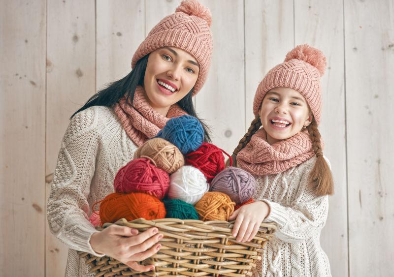 母亲和女孩在白色木制背景下玩耍