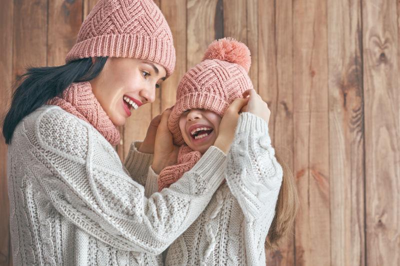 母亲和孩子女孩在白色木制背景下