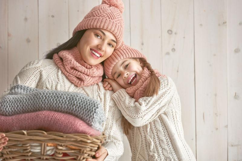 母亲和孩子在白色木制背景下玩耍