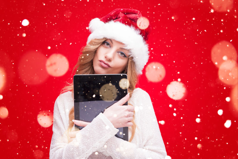 戴着圣诞帽拿着书本的美女