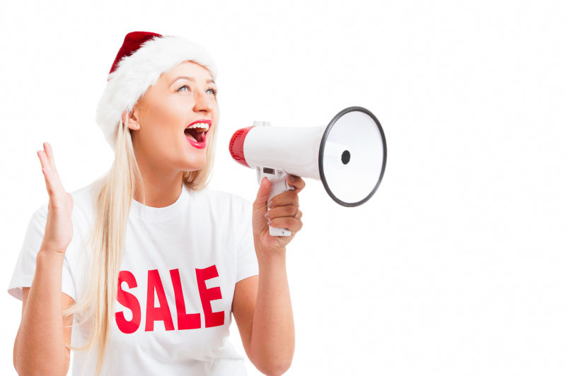 白色背景前拿着喇叭呐喊的美女