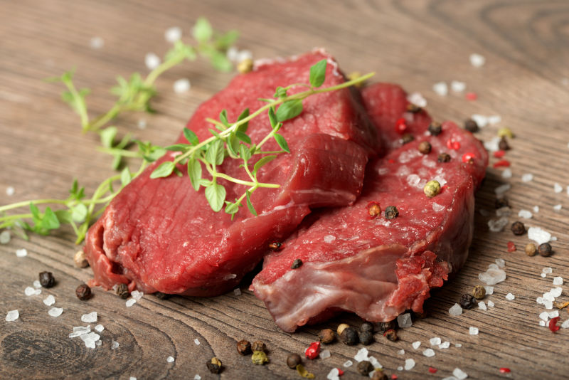 桌子上撒着香料的生肉