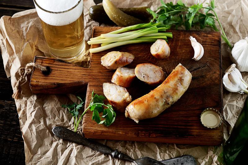 切菜板上的烤肉肠泡菜和啤酒