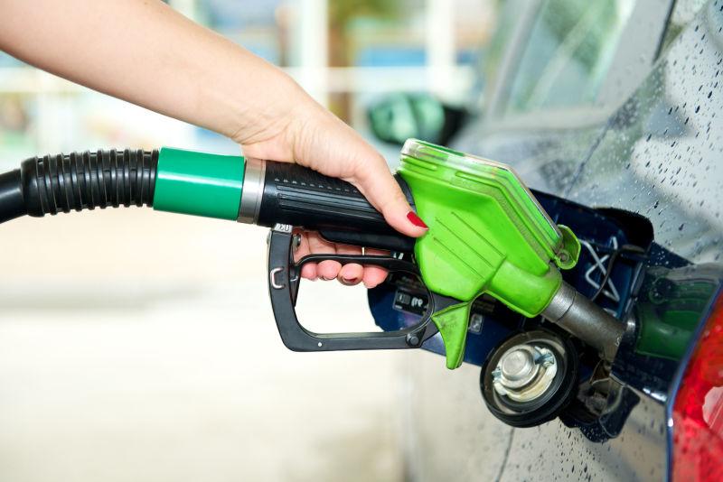 美女手上正在给汽车加油的绿色加油枪