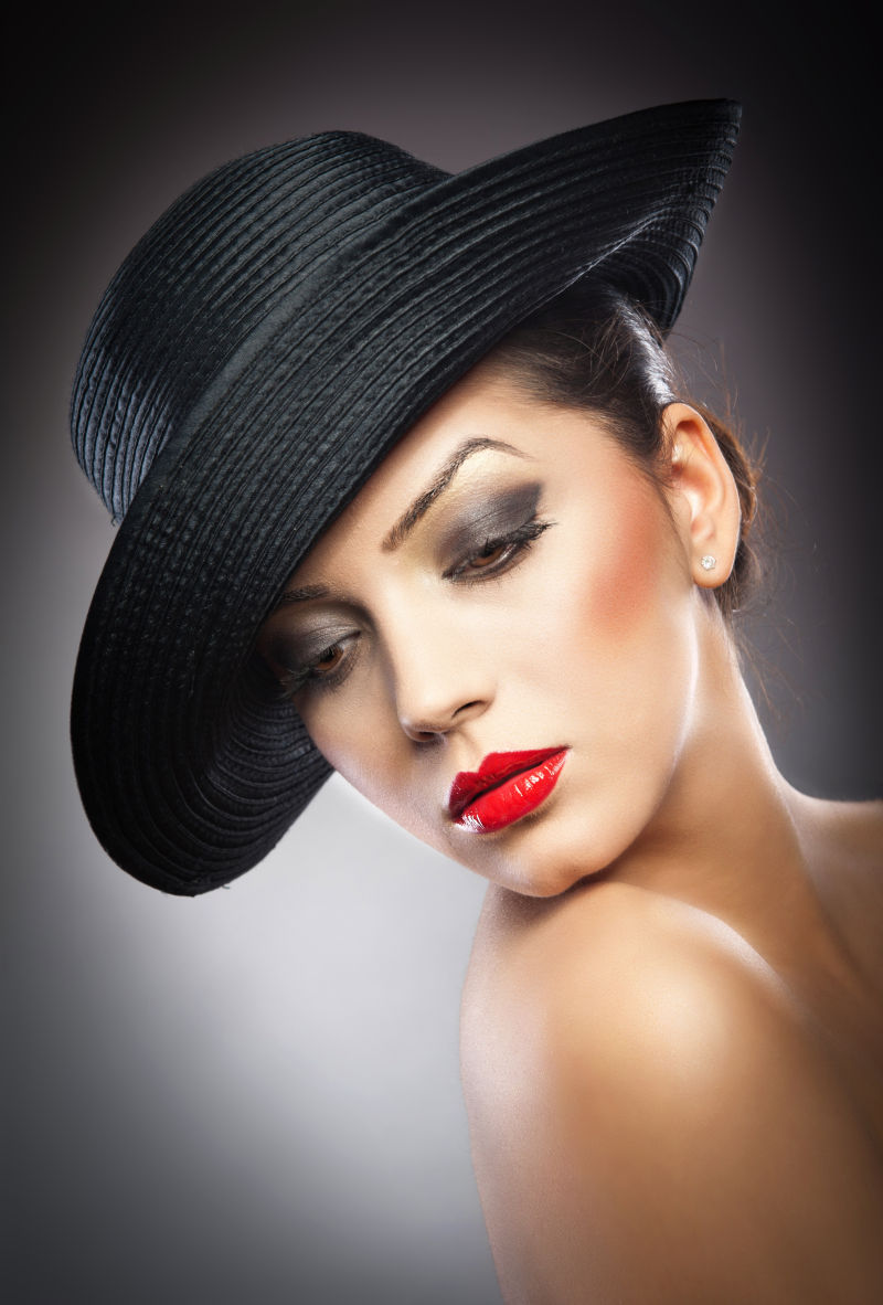 戴着黑色帽子的优雅性感的美女