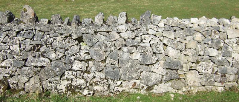 大石头垒砌的不算高的石墙背景