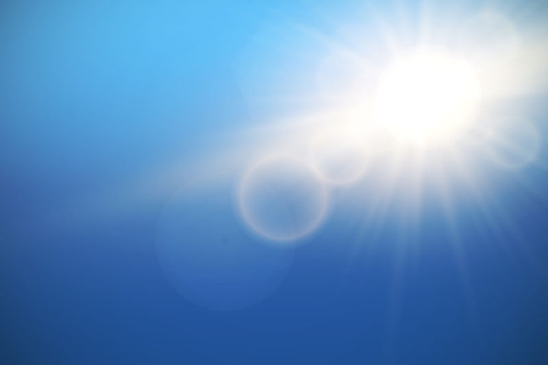 蓝色天空中的太阳光束矢量设计