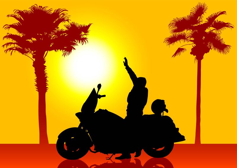 夕阳下骑摩托车的人剪影
