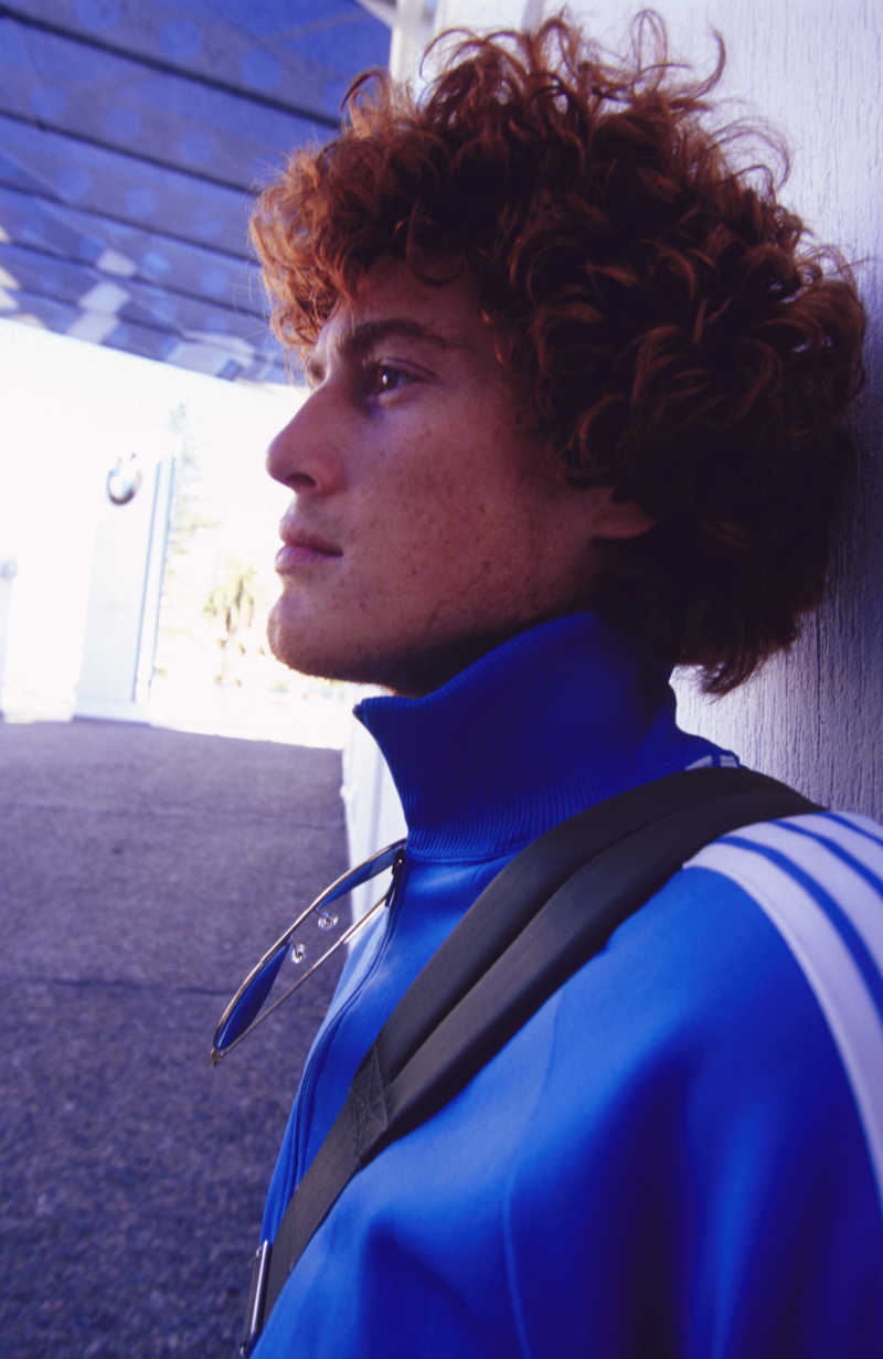 靠在墙边抬头目视远方的年轻人