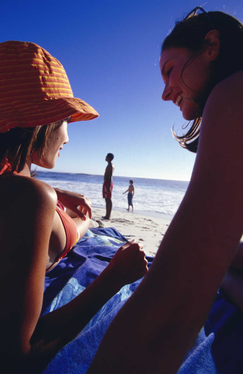 假日海滩上露出欢乐笑脸的年轻美女