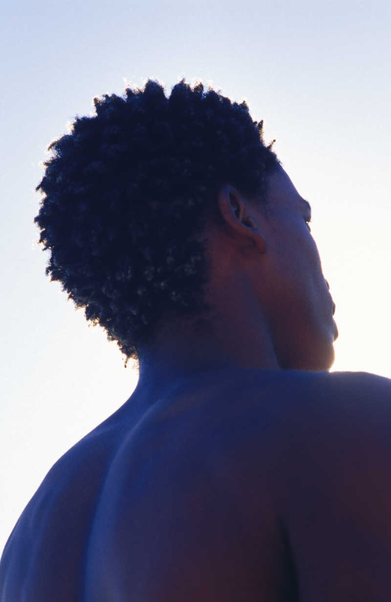 阳光下黑人男子背部特写