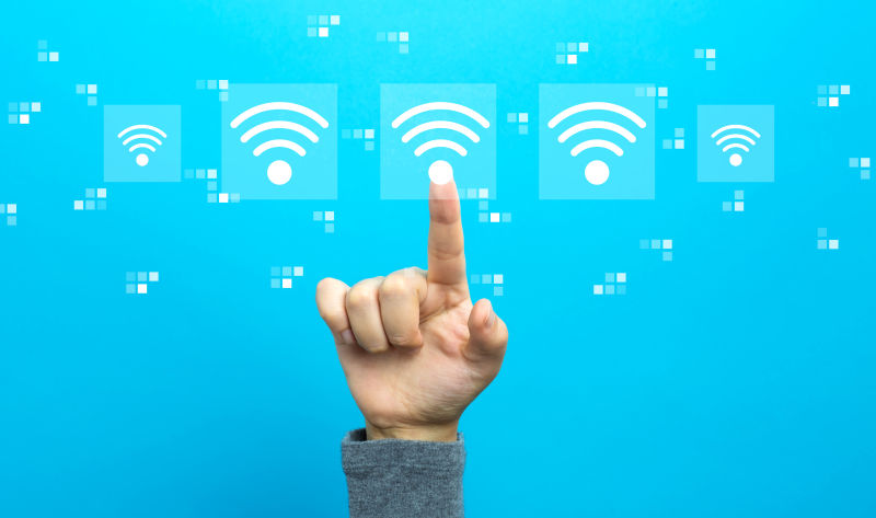 WIFI概念手放在蓝色背景上