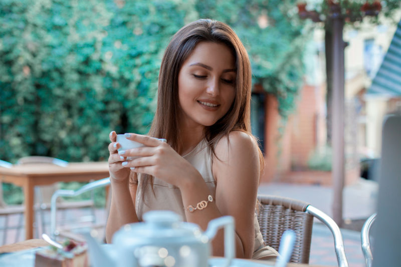 可爱的小女孩端着一杯茶