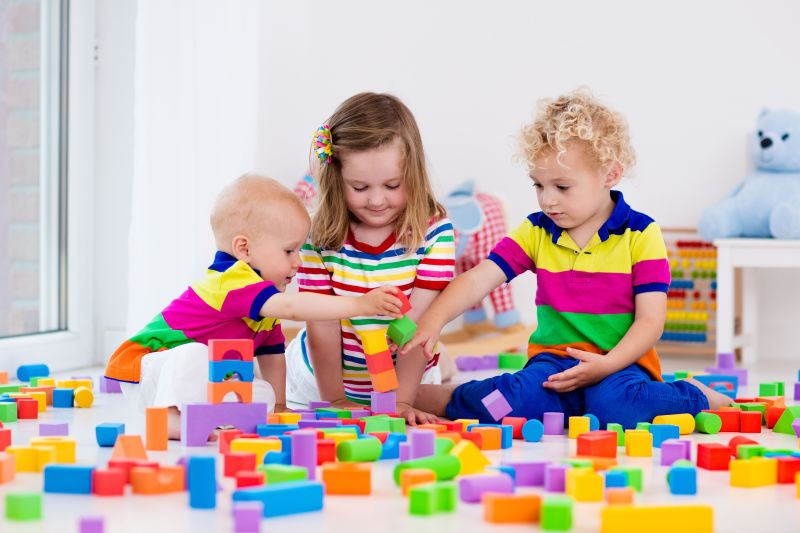 孩子们玩彩色玩具积木